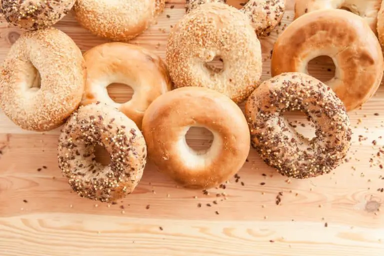 Butcher block table covered in different types of bagels 